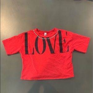 Red-black crop top with pearls aligning the neck.